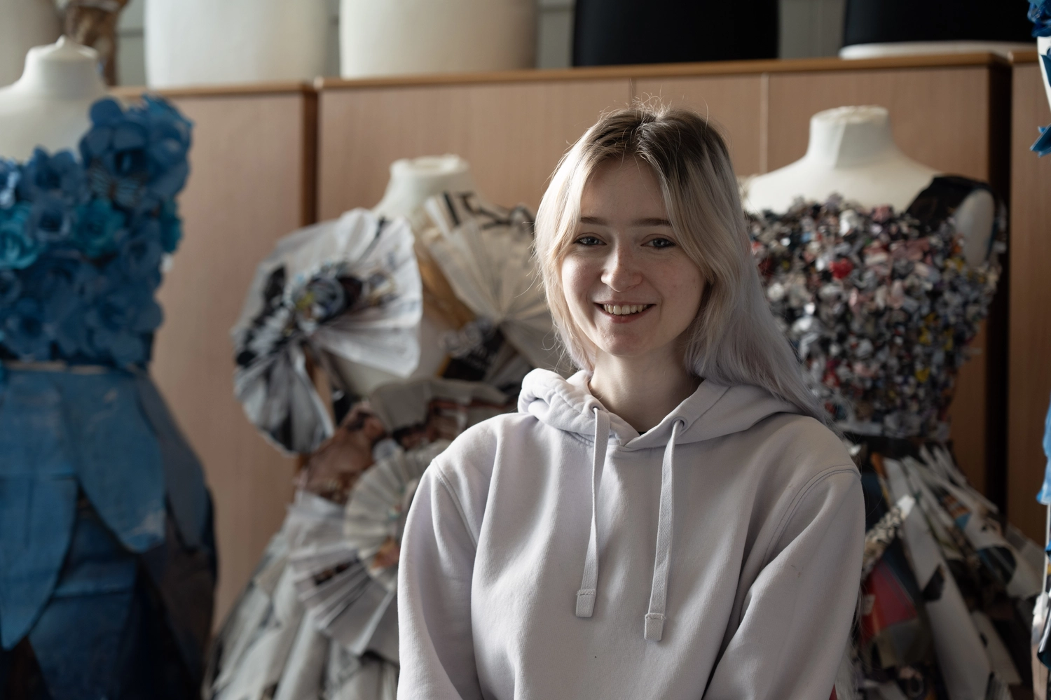 creative student in front of the fashion pieces she has created
